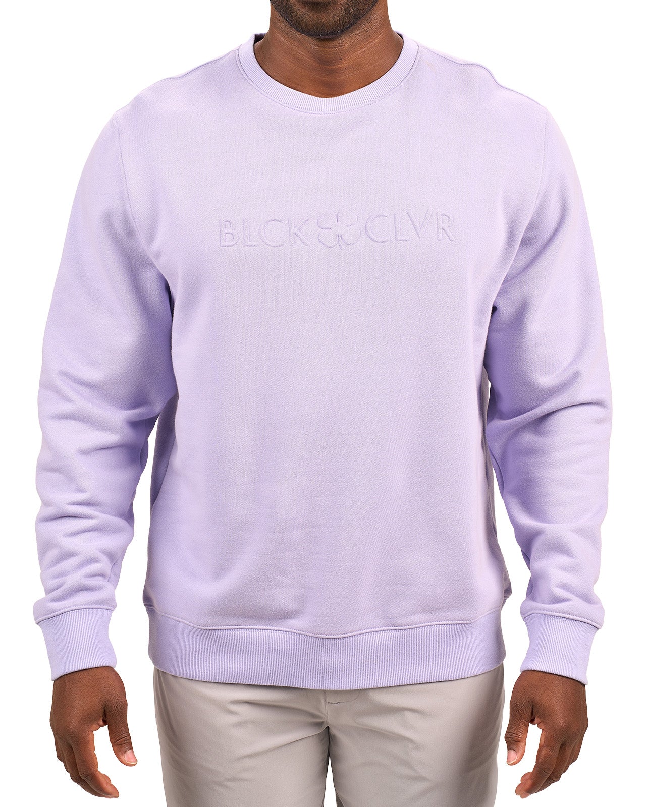 man wearing an light purple colored sweater from Black Clover with a 3d text BLCK CLVR on the chest