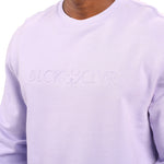 man wearing an light purple colored sweater from Black Clover with a 3d text BLCK CLVR on the chest