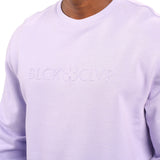 man wearing an light purple colored sweater from Black Clover with a 3d text BLCK CLVR on the chest